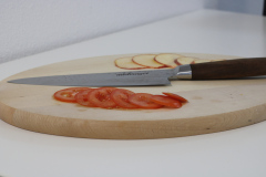 adelmayer Damastmesser Küchenmesser 20 cm 2077 Gesamtansicht auf Schneidbrett mit geschnittenem Apfel und geschnittener Tomate