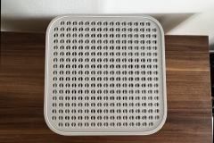 Draufsicht auf die Oberseite des Routers mit symmetrisch angeordneten, runden Lüftungslöchern zur Belüftung.