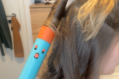 Anwendung des Lockenaufsatzes in Aktion: Der konische Aufsatz mit App-Anbindung wickelt Haarsträhnen automatisch ein – Luftstrom und Temperatur werden individuell angepasst. (Foto: Testsieger.de)