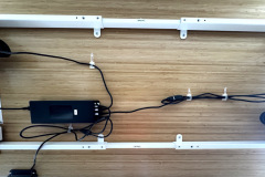 Clevere Lösung für ein sauberes Setup: Mitgelieferte Kabelkleber halten Netzteil und Kabel sicher unter der Tischplatte. (Foto: Testsieger.de)