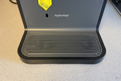 Die geriffelte Tropfschale sitzt unterhalb des Wasserauslaufs und nimmt ablaufendes Wasser auf. Der Hydrofast Schriftzug kennzeichnet die Gerätefront. (Foto: Testsieger.de)