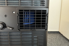 Der Abluftschlauch wird stabil am Gehäuse fixiert – die Verarbeitung macht insgesamt einen sicheren Eindruck. (Foto: Testsieger.de)Die Entleitung der warmen Luft erfolgt bequem über den Ablass an der Rückseite – (Foto: Testsieger.de)