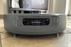 Frontaler Blick auf die Kameraeinheit des Roboters. Zwei Linsen sind in einem schwarzen Modul mittig eingebettet, beschriftet mit „TwinAI Dodge – Designed by Narwal“. Unter dem Gerät sind zwei Seitenbürsten zu sehen.