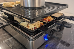 Zwei Welten auf einmal: Oben grillen, unten racletten, genau dafür ist das Kombigerät gemacht, verlangt aber etwas Aufmerksamkeit, damit kein Pfännchen zu weit nach hinten rutscht und am Topf anbackt. (Foto: Testsieger.de).