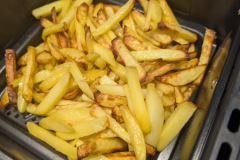 Frische Kartoffelstäbchen bleiben die Schwachstelle: Trotz 45 Minuten und häufigem Schütteln zeigen die Pommes deutlich rohe und ungleichmäßig gegarte Stücke. (Foto: Testsieger.de)