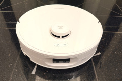 Die Frontansicht zeigt den Hinderniserkennungssensor sowie die zwei Seitenbürsten, die im Test dazu beitragen, dass 49 von 50 Gramm Schmutz auf Hartboden aufgenommen werden. Auf Teppich nimmt der Roboter lediglich rund 80 Prozent des Schmutzes auf. (Foto: Testsieger.de)