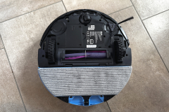 Blick auf die Unterseite des Shark PowerDetect NeverTouch Pro. Sichtbar sind die Hauptbürste, Seitenbürste, Räder und das Wischpad. Die Bauweise zeigt eine robuste Verarbeitung.