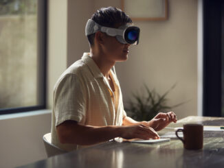 Blick von der Seite auf einen Mann, der mit der Apple Vision Pro arbeitet (Foto: Apple)