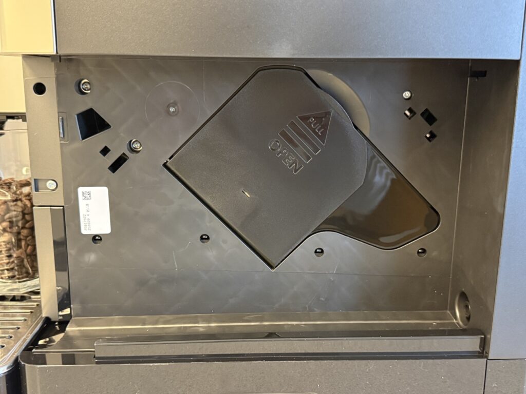 Geöffnete Wartungsklappe mit herausnehmbarer Brühgruppe der De’Longhi PrimaDonna Aromatic.