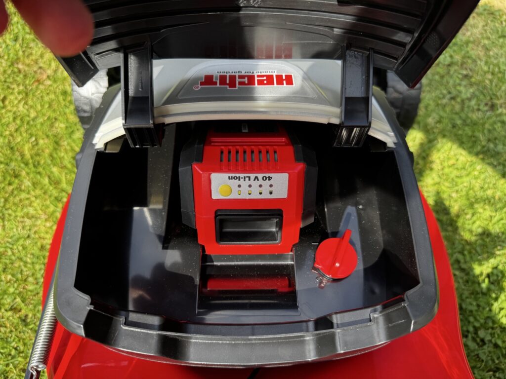 Eingesetzter 40-Volt-Akku des Hecht 5041S im geöffneten Fach mit rotem Sicherungshebel.