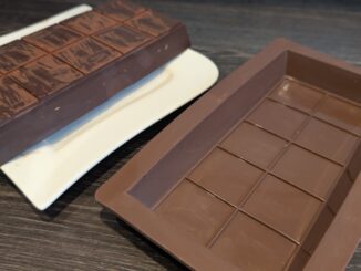 Silikonform und fertig herausgelöste Schokoladentafel nebeneinander.