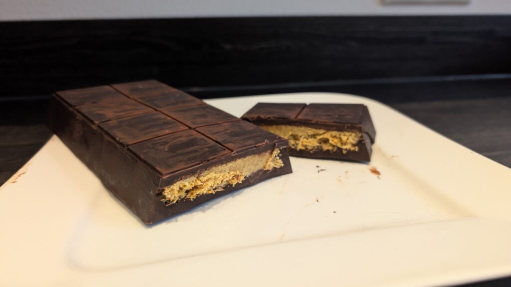 Aufgeschnittene Schokoladentafel mit goldbrauner Füllung im Inneren.