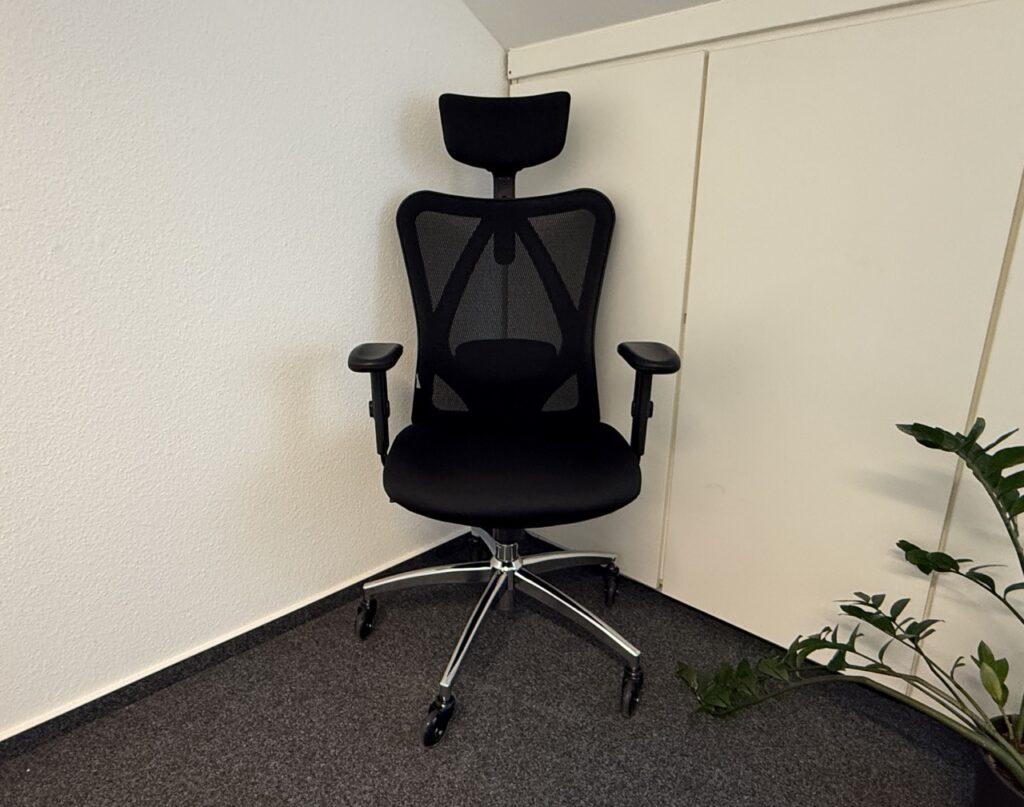 Ergonomischer Bürostuhl Sihoo M18 mit Kopfstütze und Netzrückenlehne in einem Büro.