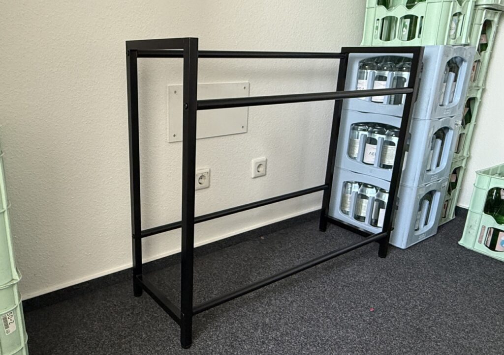 Leeres STEELSØN Macondo Getränkekistenregal aus schwarzem, pulverbeschichtetem Metall, frontal aufgenommen.