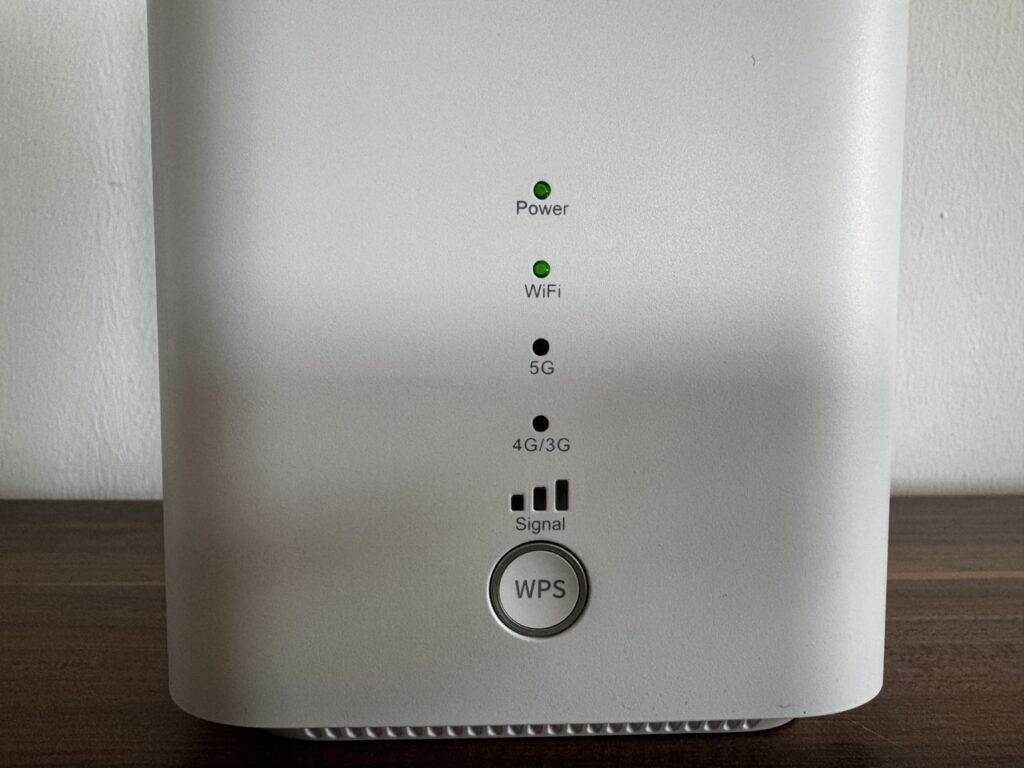 Nahaufnahme der Vorderseite des Routers mit grünen Status-LEDs für Power, WLAN, 5G, 4G/3G sowie einem großen WPS-Knopf.