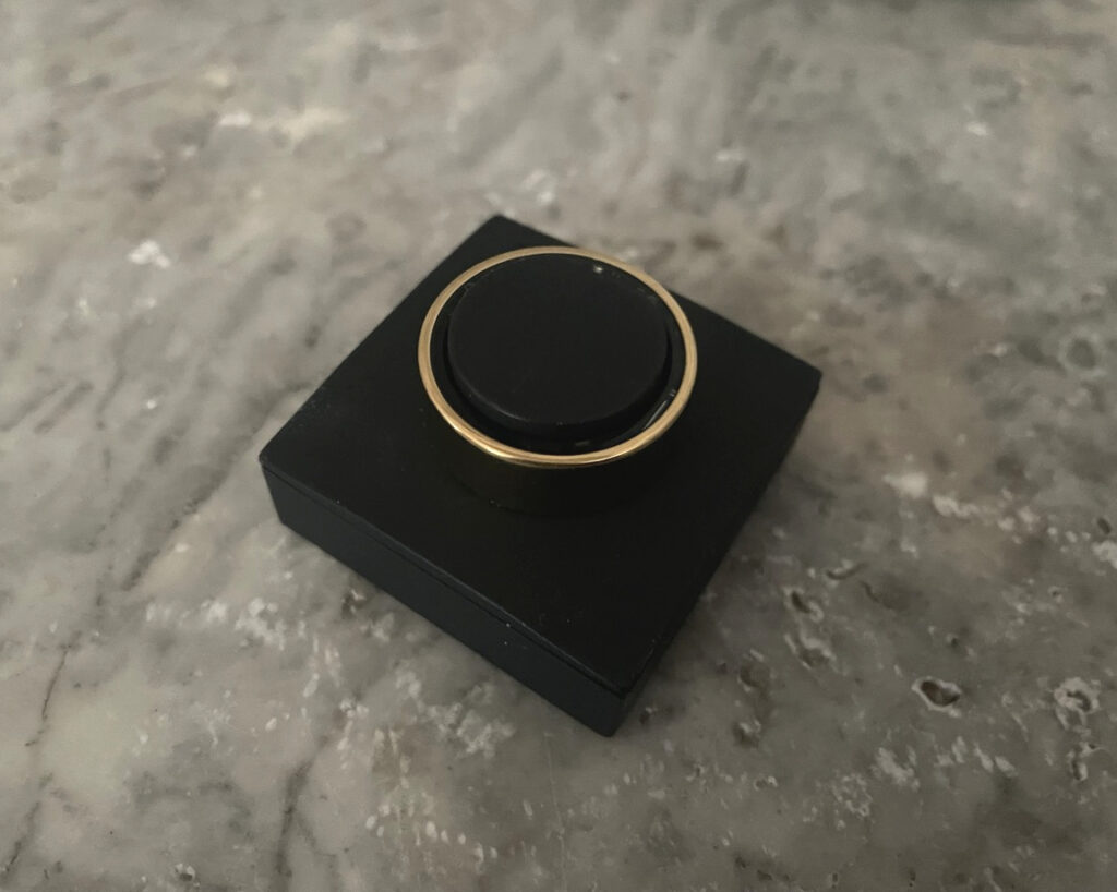 UltraHuman Ring AIR in der Farbe Bionic Gold auf der schwarzen Ladestation.