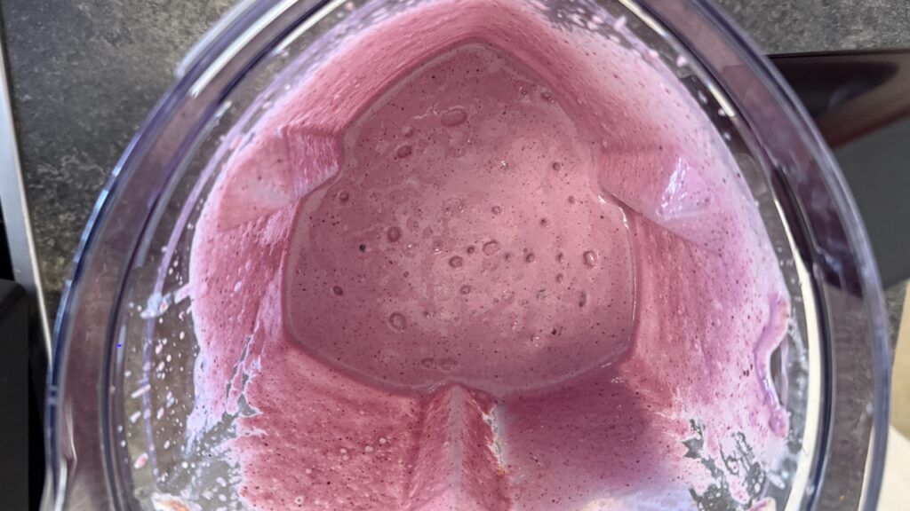 Blick von oben in den Mixbehälter des Braun PowerBlend 9 mit fertig gemixtem Beeren-Smoothie und gleichmäßiger, cremiger Konsistenz.