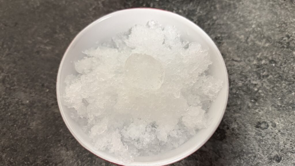 In einer Schale angerichtetes Crushed Ice aus dem Braun PowerBlend 9 mit überwiegend feiner Struktur und einzelnen größeren Eisstücken.