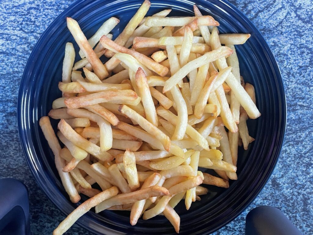 „COSORI Dual Basket 8,5 L“: Portion knuspriger Pommes auf dem Teller