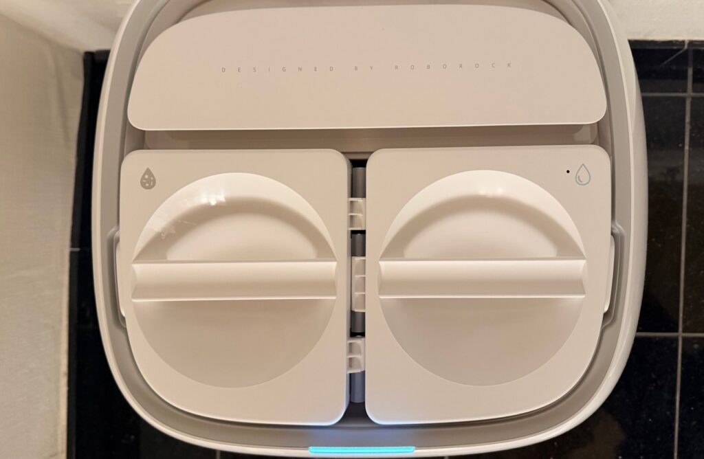 Roborock Qrevo Curv 2 Flow: Draufsicht in die geöffnete Reinigungsstation mit Frisch und Schmutzwasserbehälter