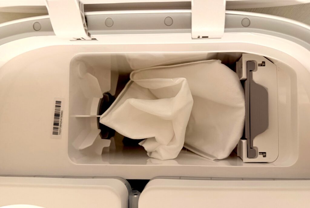 Roborock Qrevo Curv 2 Flow: Staubbeutel im geöffneten Staubbehälter der Reinigungsstation