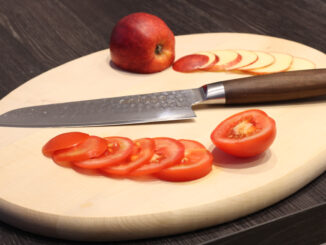 adelmayer Damastmesser Santokumesser 17,5 cm Gesamtansicht auf Schneidbrett mit geschnittener Tomate und geschnittenem Apfel
