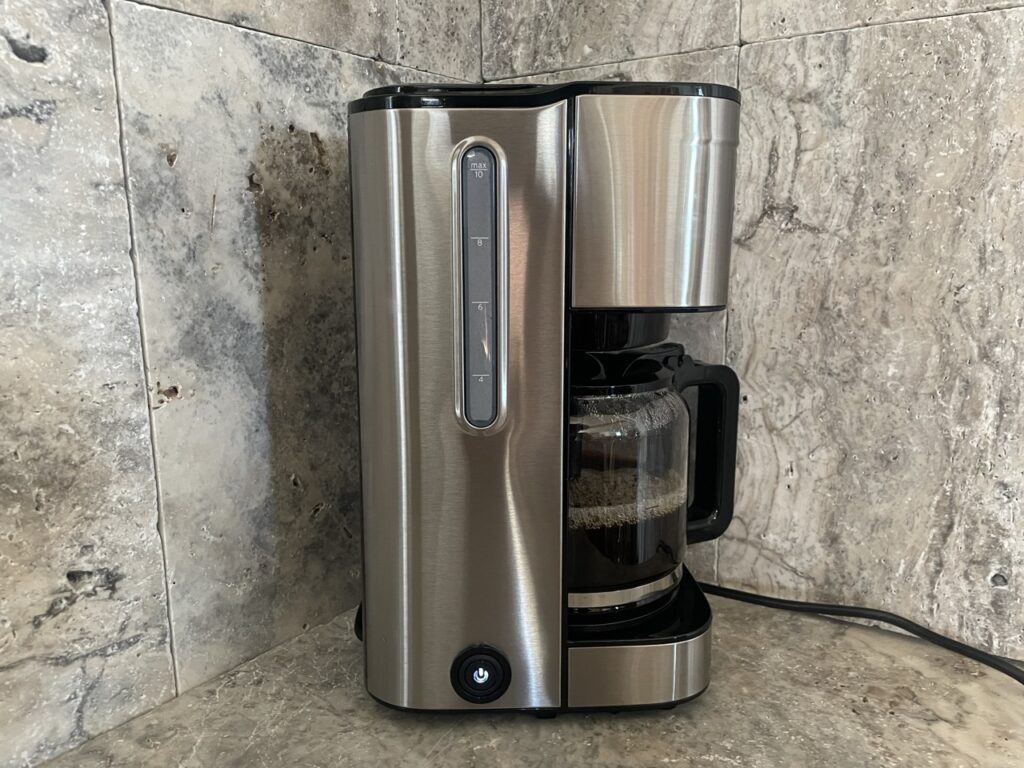 „Tchibo Let’s Brew Elegant“:„Seitenansicht mit Wasserstandsanzeige und beleuchtetem Schalter“